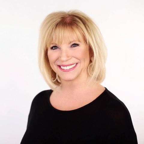 photo of a blond woman wearing a black blouse